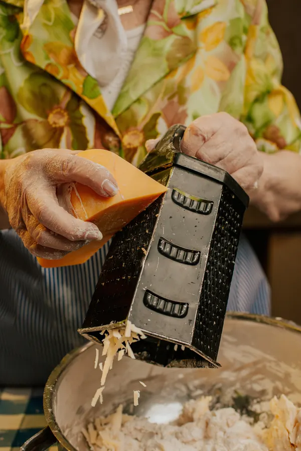 La abuela rallando queso para la masa